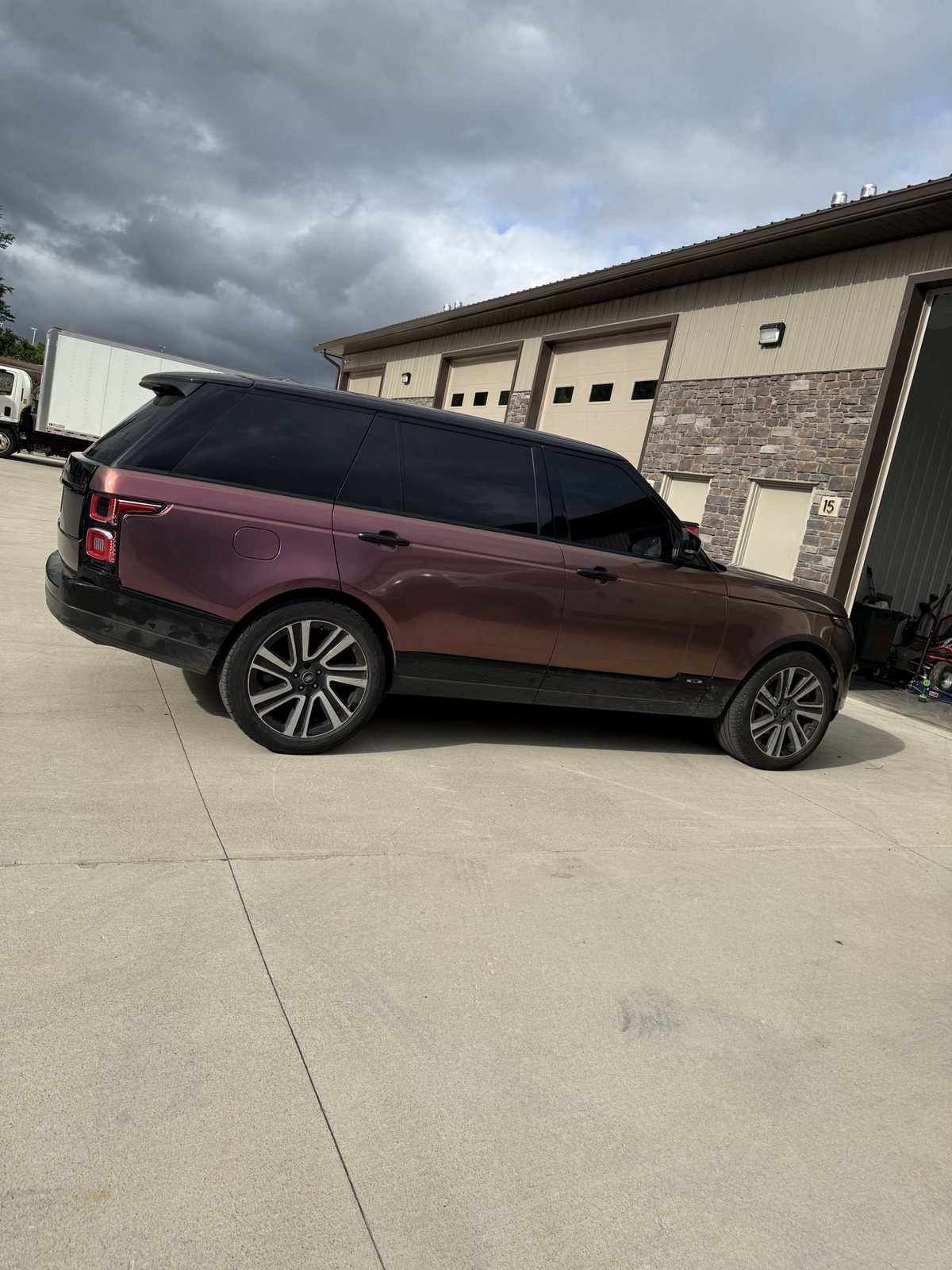 Range Rover in a purple and bronze color-shift full wrap outside the shop