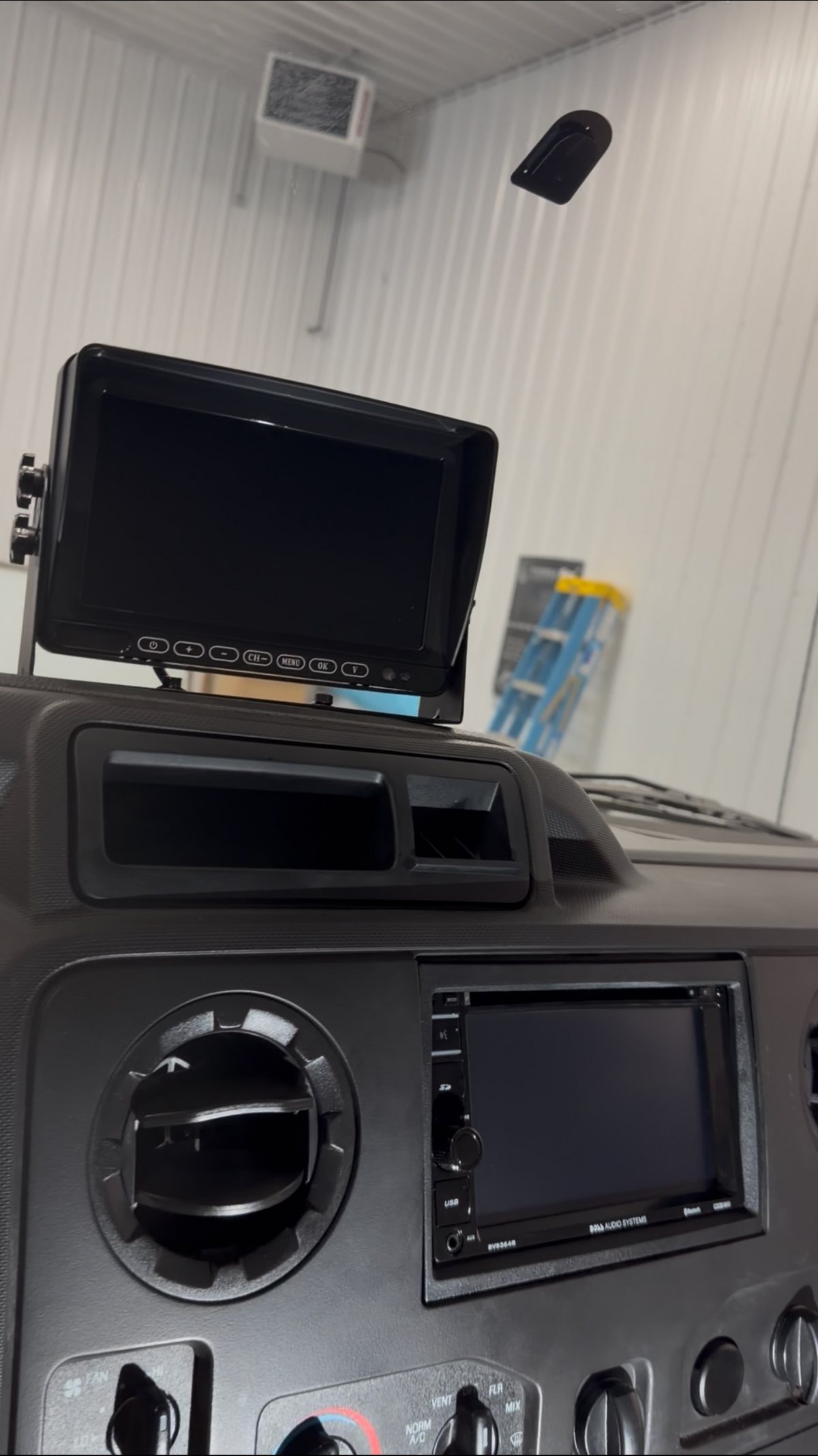 Ford E-350 dash finished with a Boss touchscreen head unit and a backup camera monitor