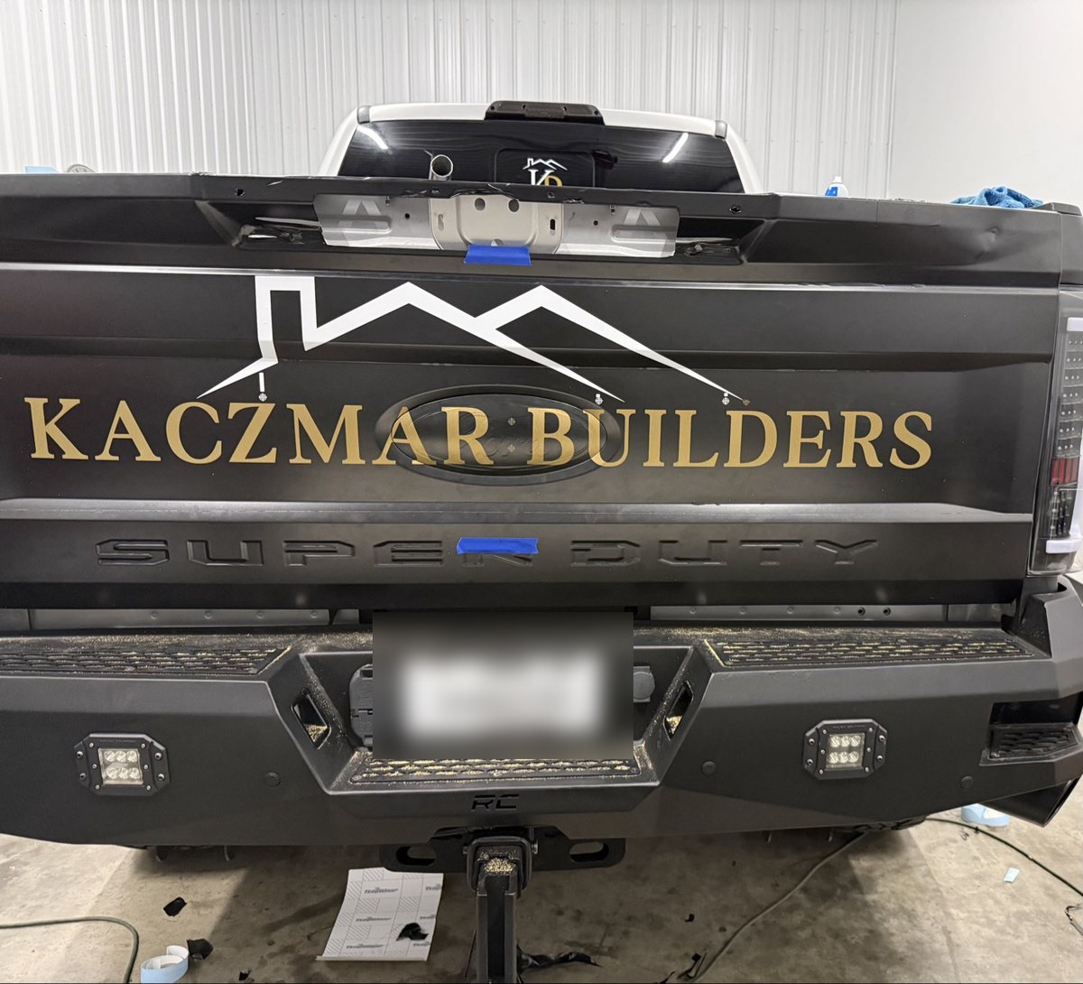 Kaczmar Builders gold tailgate lettering on a satin black Super Duty