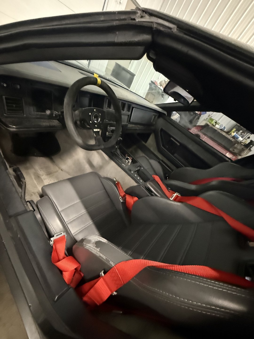Past shop build — 1985 Corvette interior with racing seats, red harnesses and quick-release steering wheel