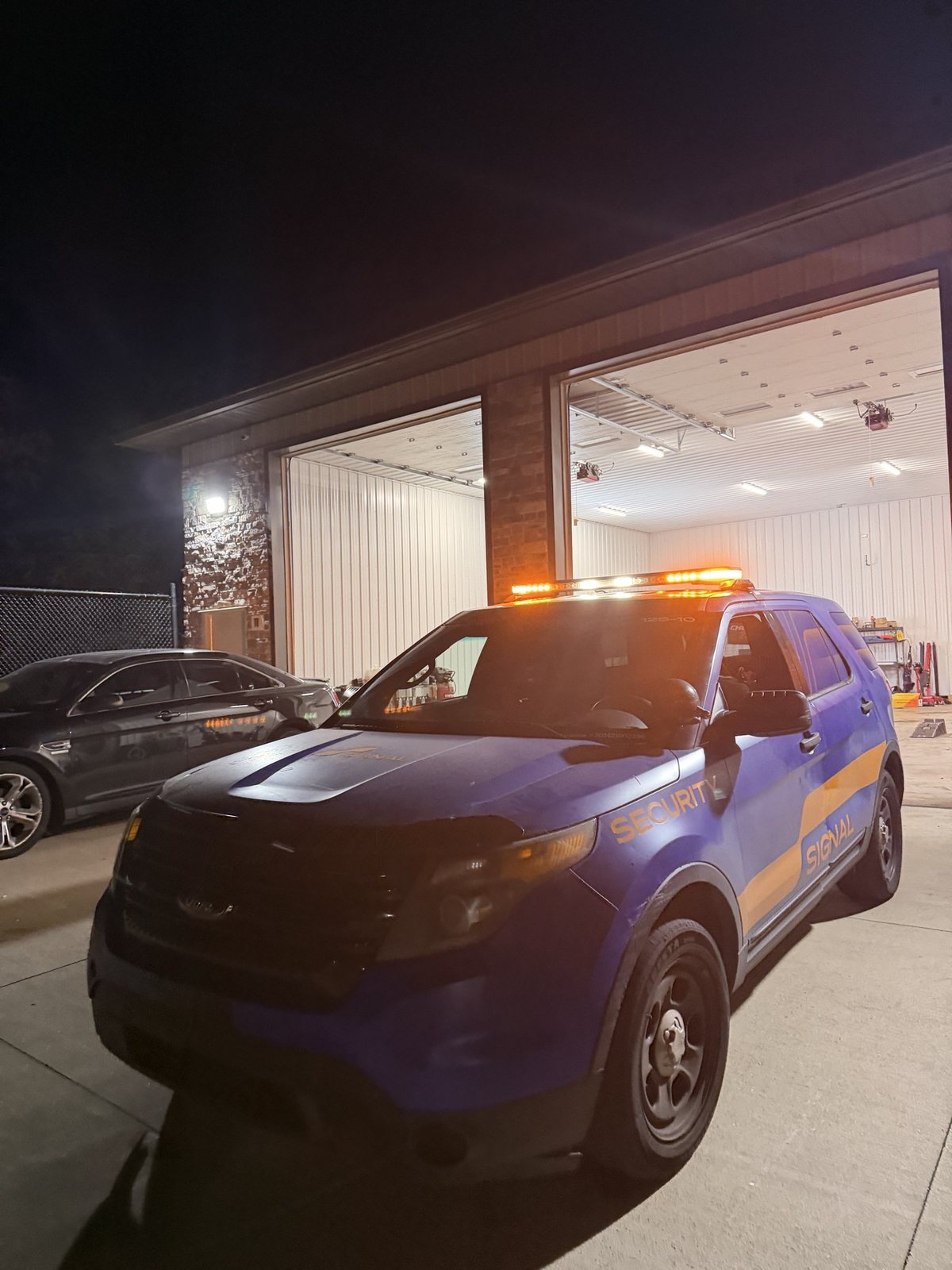Signal Security Ford Explorer outside the shop at night with its amber roof light bar lit
