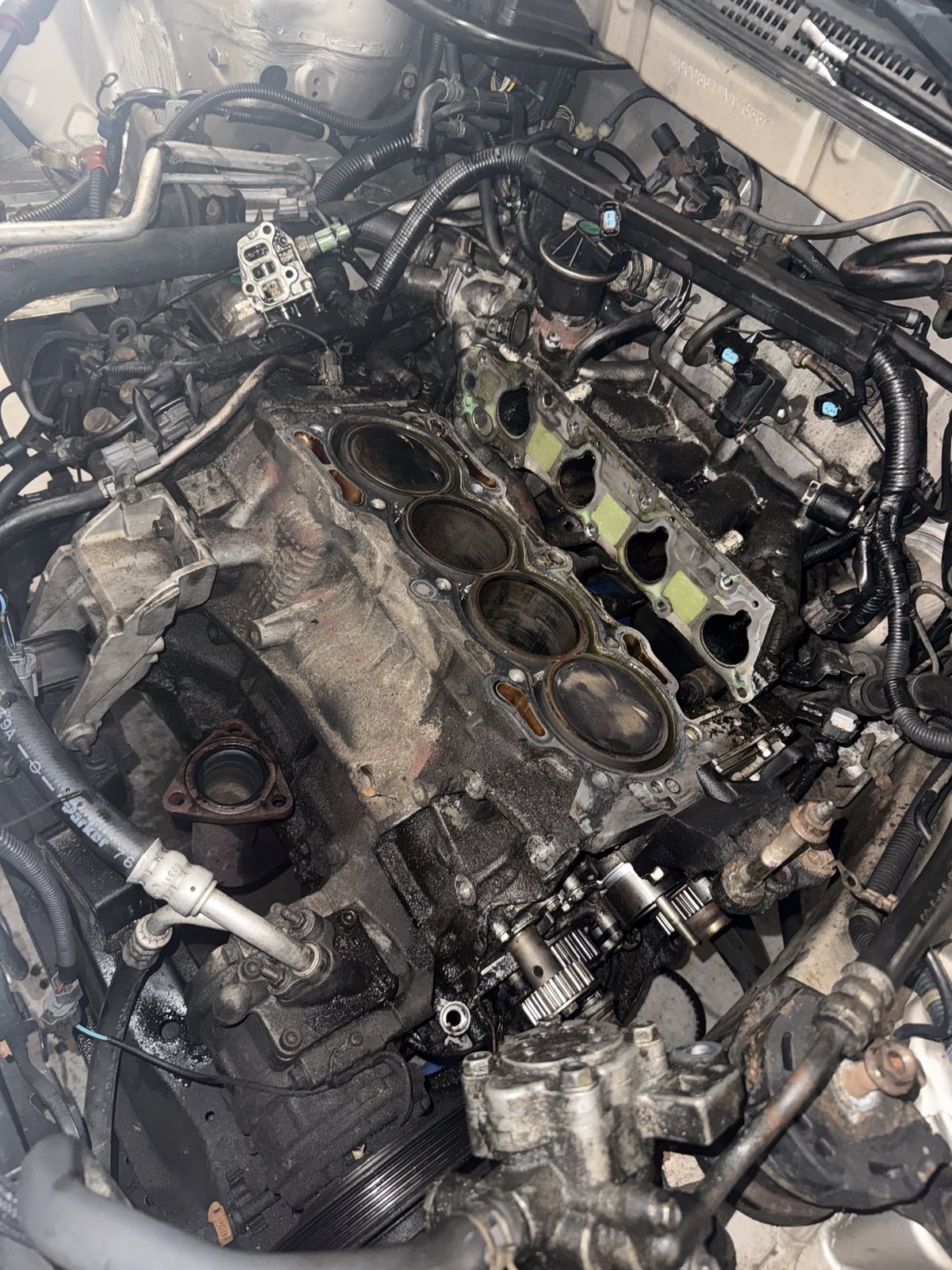 Bare engine block deck with pistons exposed during a head gasket job