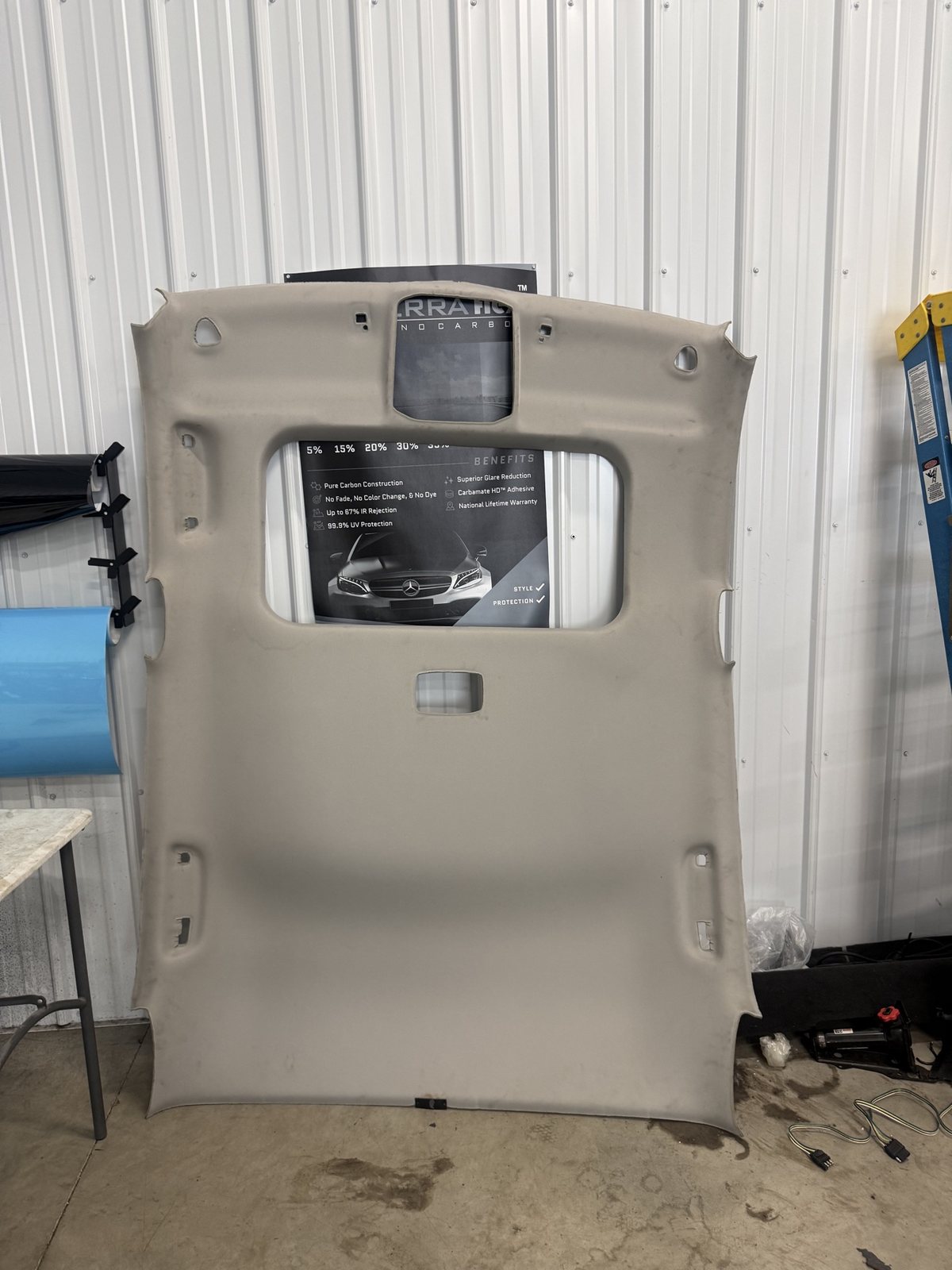 Stock beige headliner board removed from a vehicle, before the starlight conversion