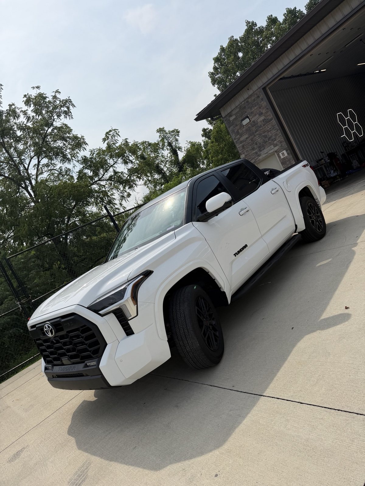 Toyota Tundra finished with a black roof and pillar two-tone wrap outside the shop