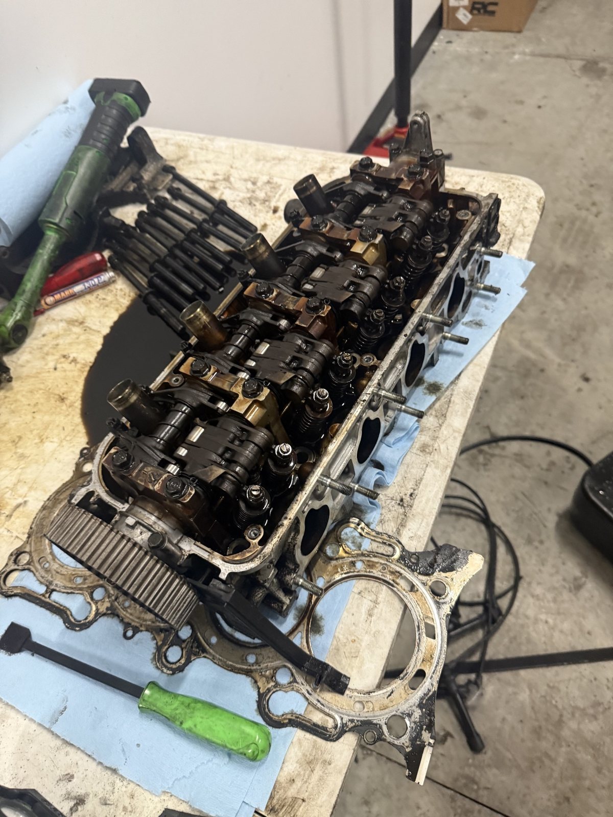 Toyota cylinder head on the work bench with its old gasket and head bolts