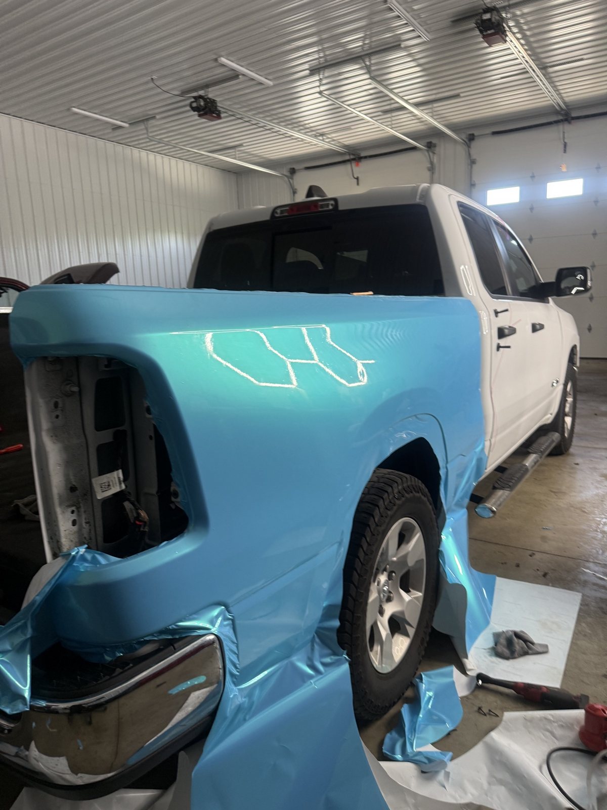 Ram 1500 bed being wrapped in light blue pearl vinyl inside the 1Stop shop