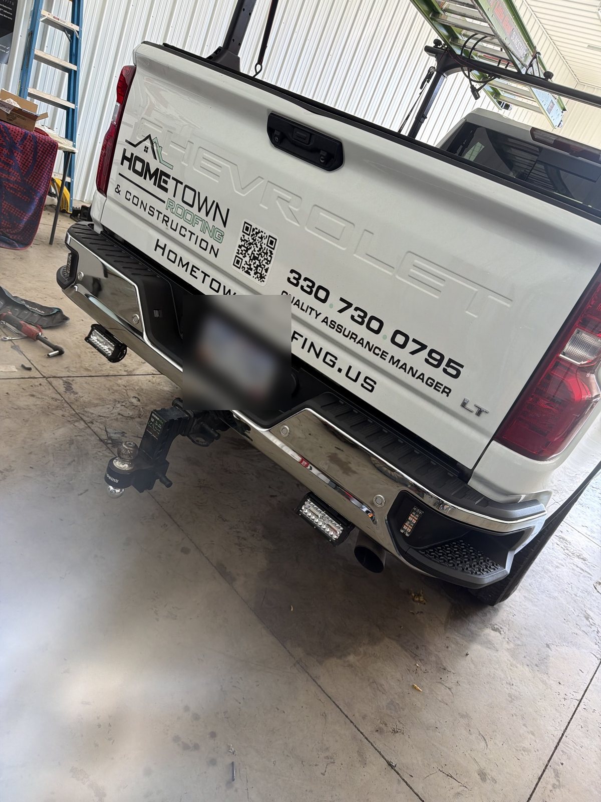 Hometown Roofing Silverado rear view in the shop with LED bumper work lights fitted