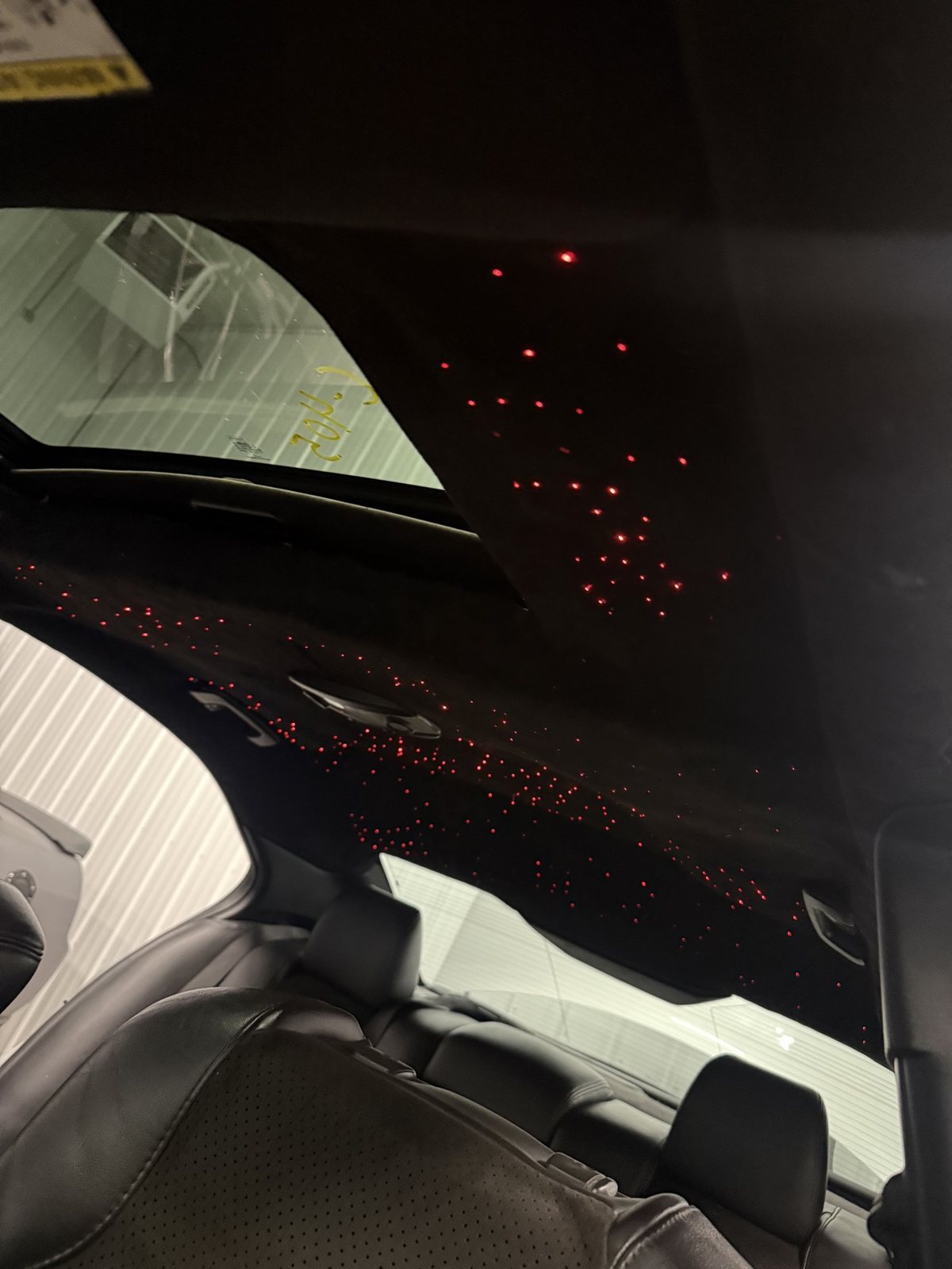 Finished starlight headliner glowing red inside a sedan