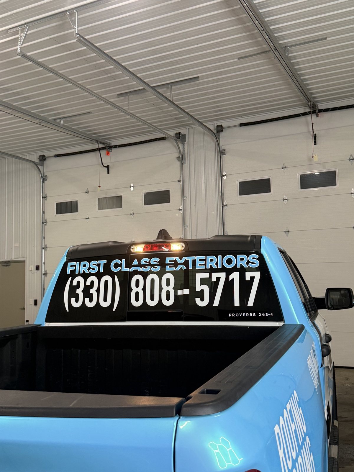Rear window lettering for First Class Exteriors with phone number on the wrapped Ram truck